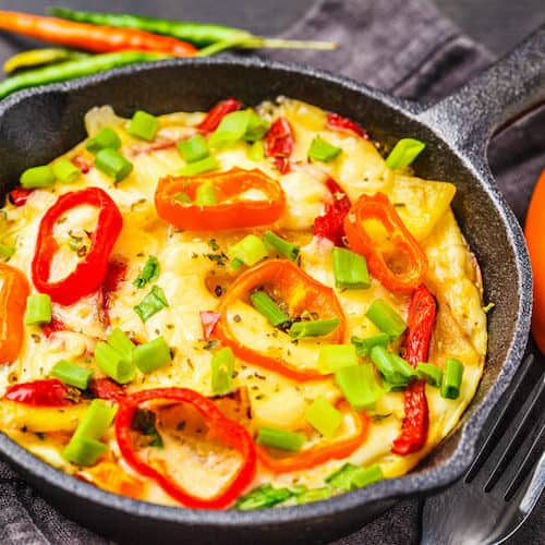 Traditional fritatta with peppers. Dark wooden background