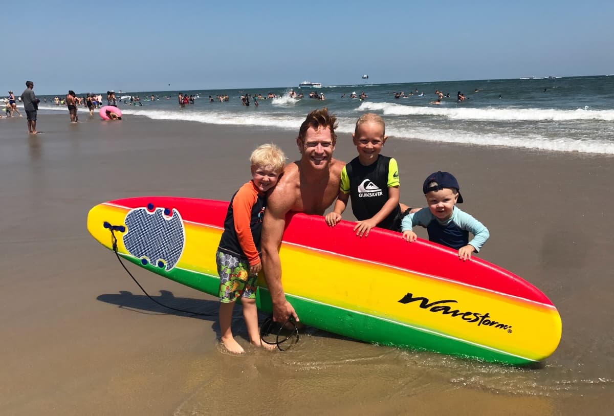 family surfing at the beach in the ocean
